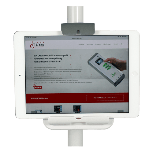 Tablet in Halterung zeigt Webseite eines Dental-Leuchtmessgeräts mit Bedienelementen und Kontaktinformationen.